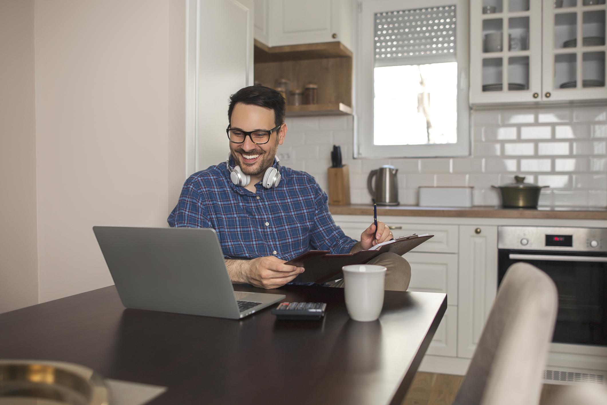 Businessman making notes in his notebook while working remotely