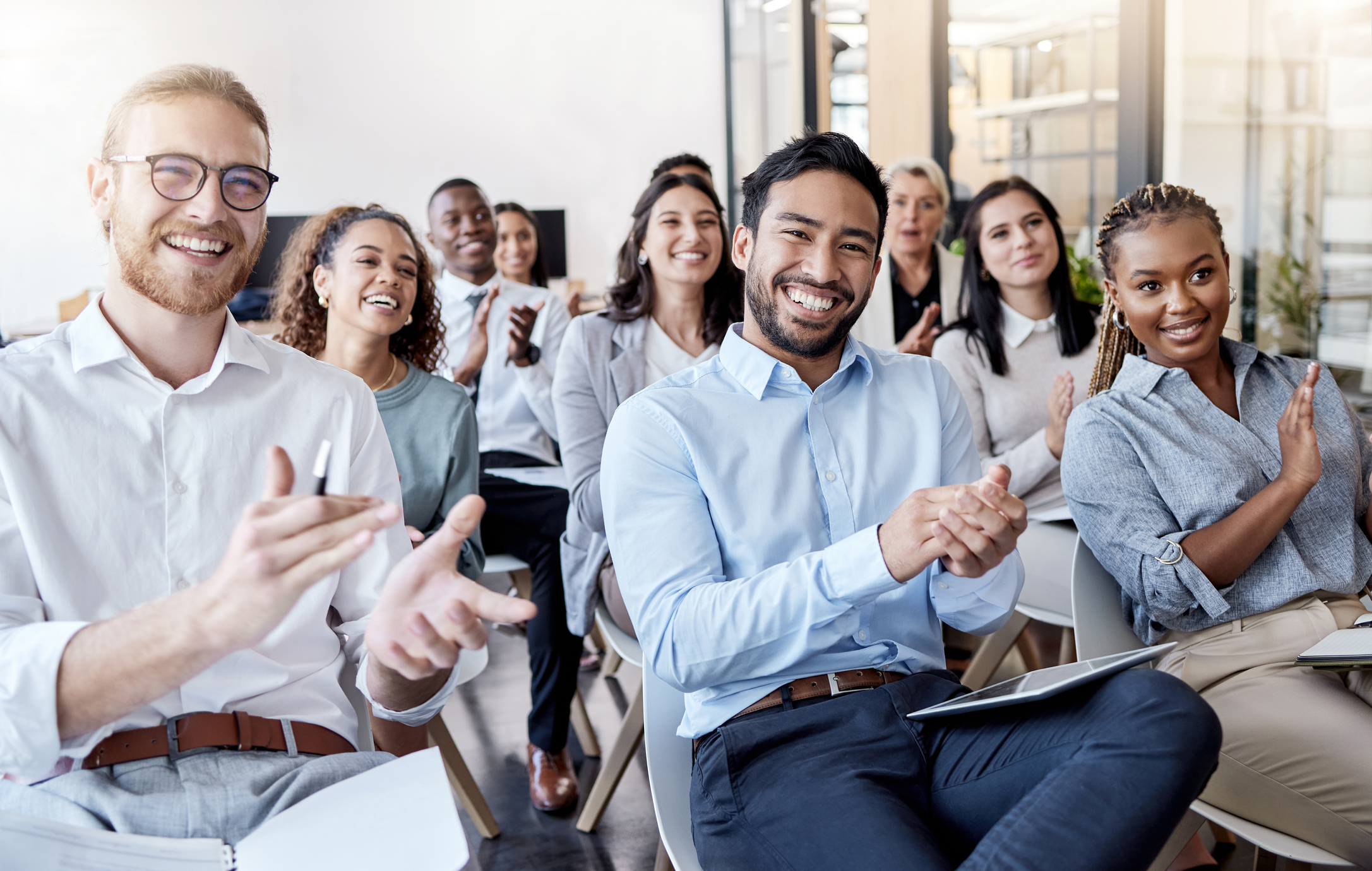 Photo of a group of business people clapping hands.
