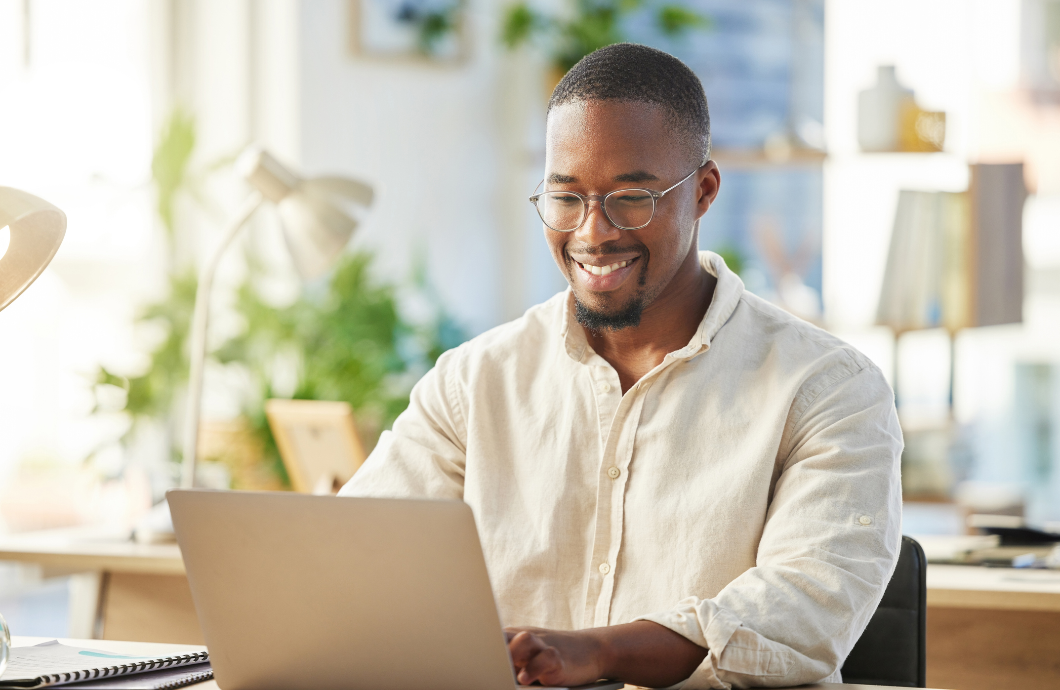 Photo of a young businessman working on his laptop at his desk