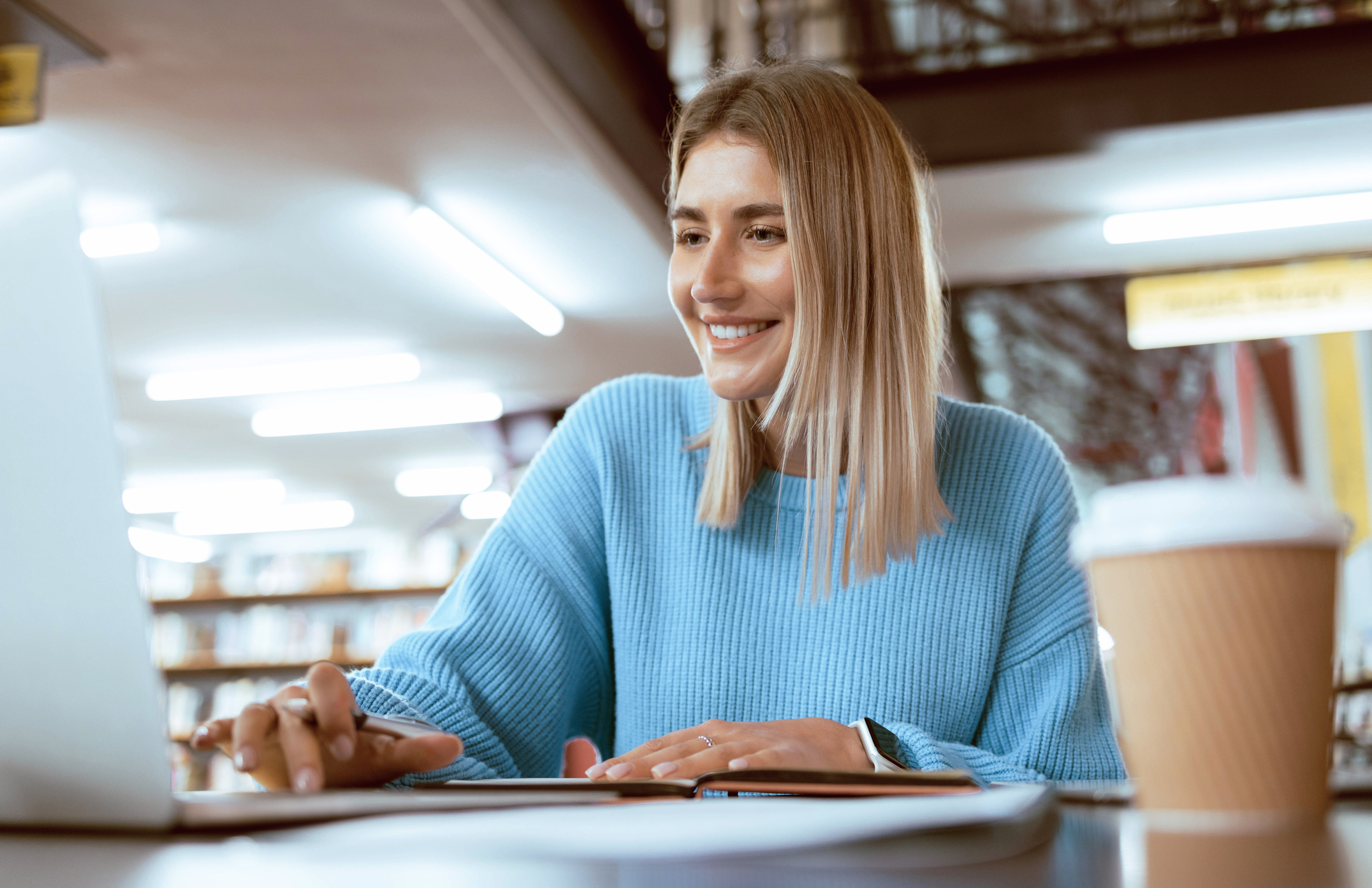 Education, university and happy woman in library with laptop
