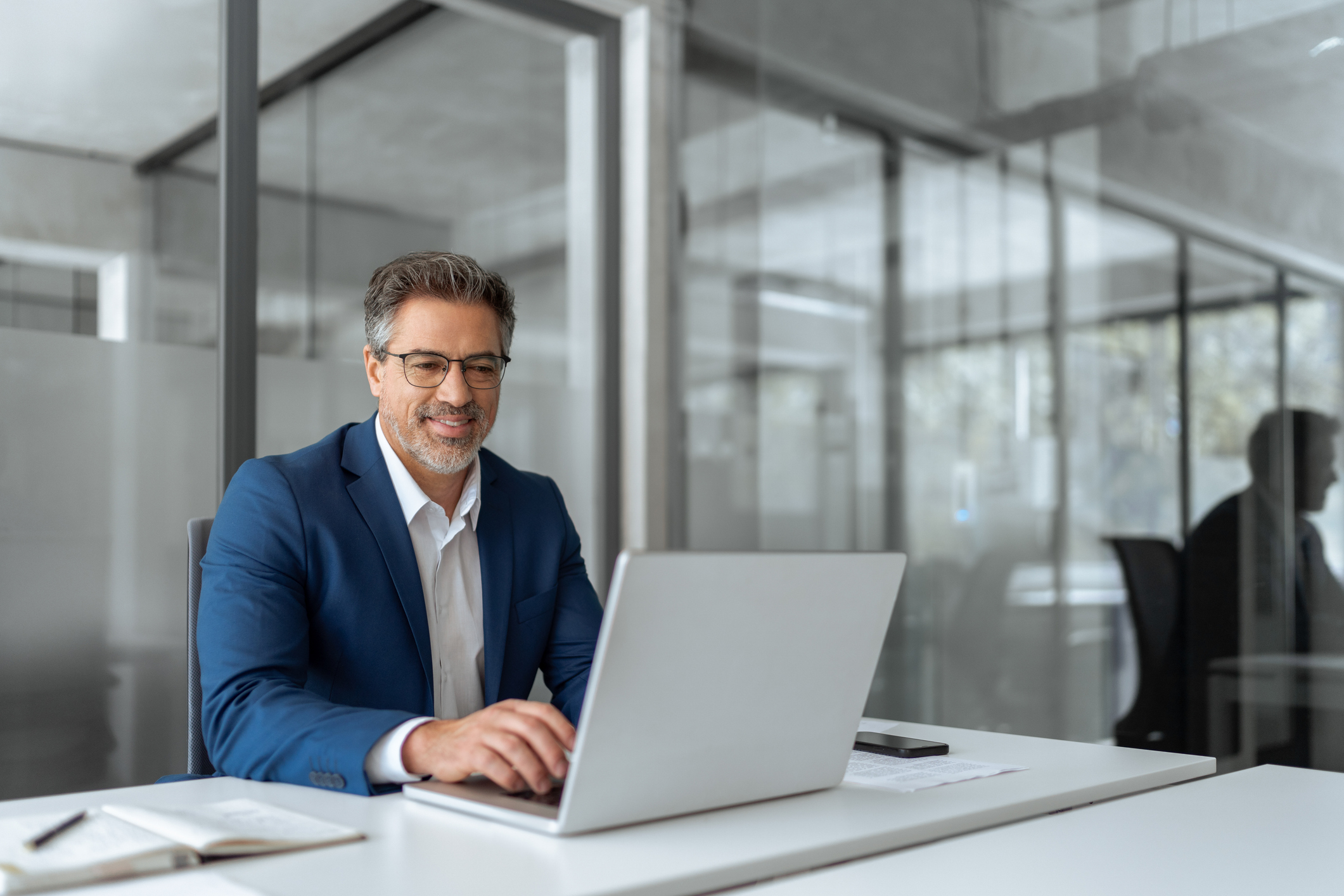 GettyImages-2211175038 Photo of a man working at a computer in an office