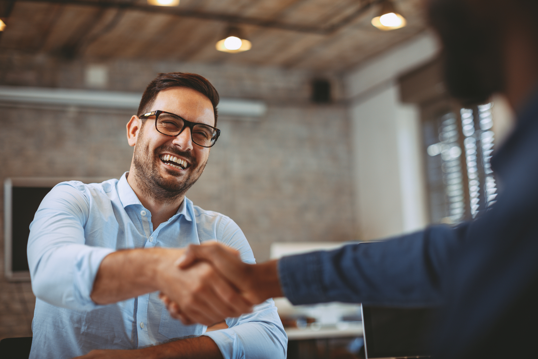 GettyImages-935659716 Close up photo of handshake in the office