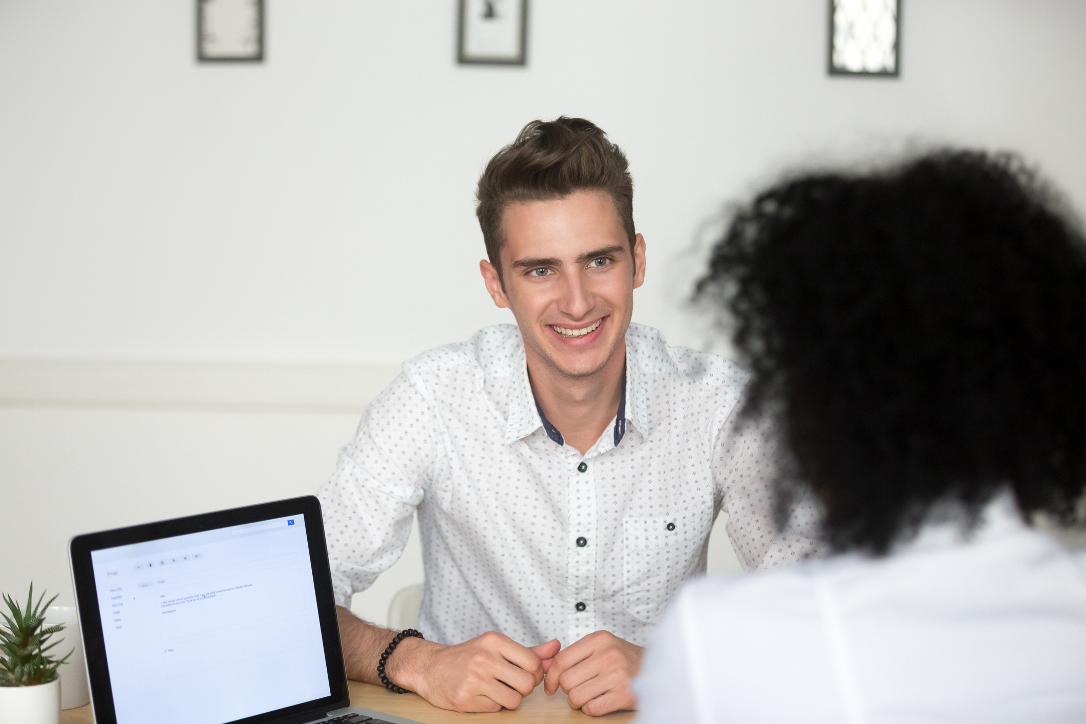 Photo of Smiling job candidate happily answering recruiter question during interview