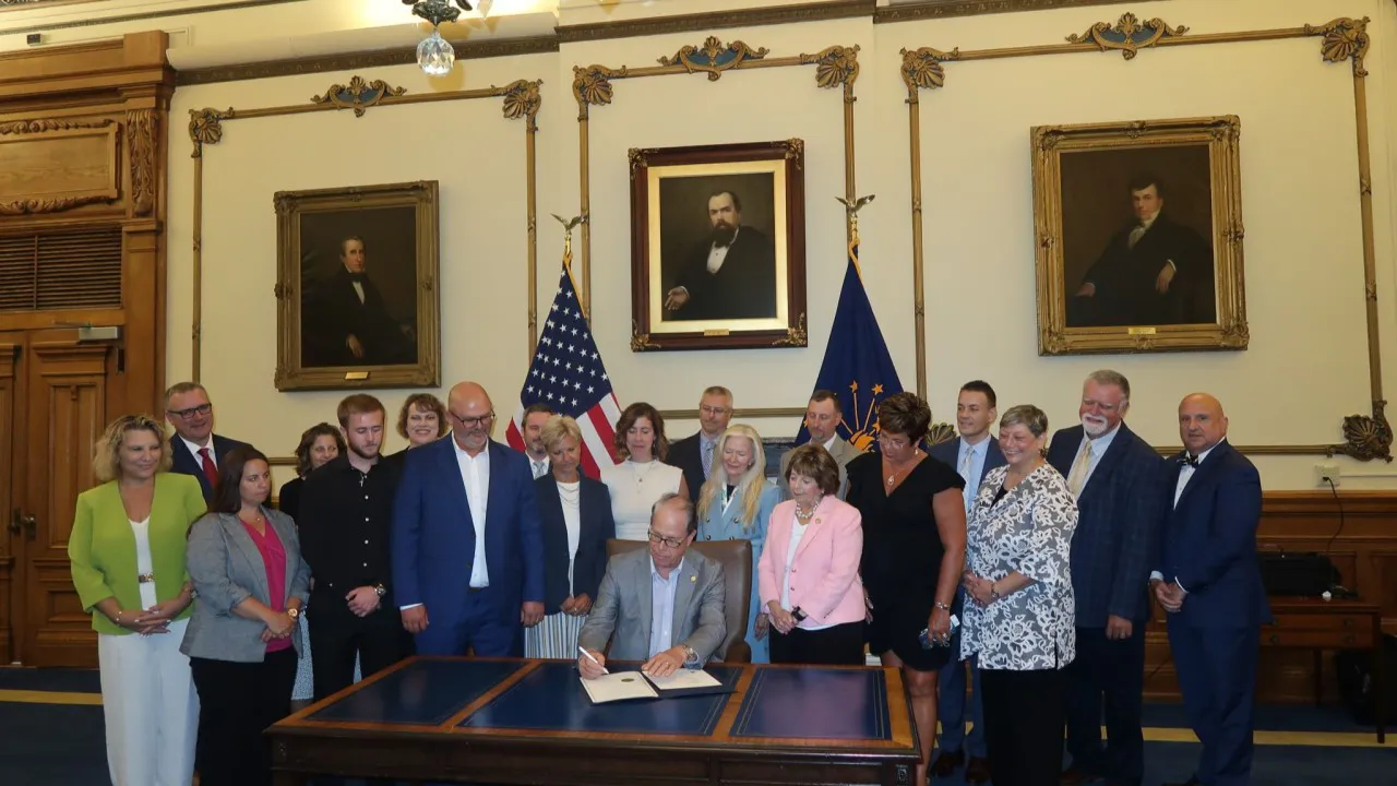 Photo of bill signing and the Indiana Statehouse