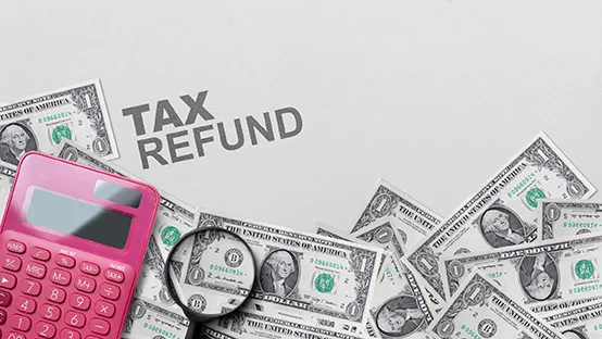 Photo of Tax Refund showing dollar bills calculator and magnifying glass